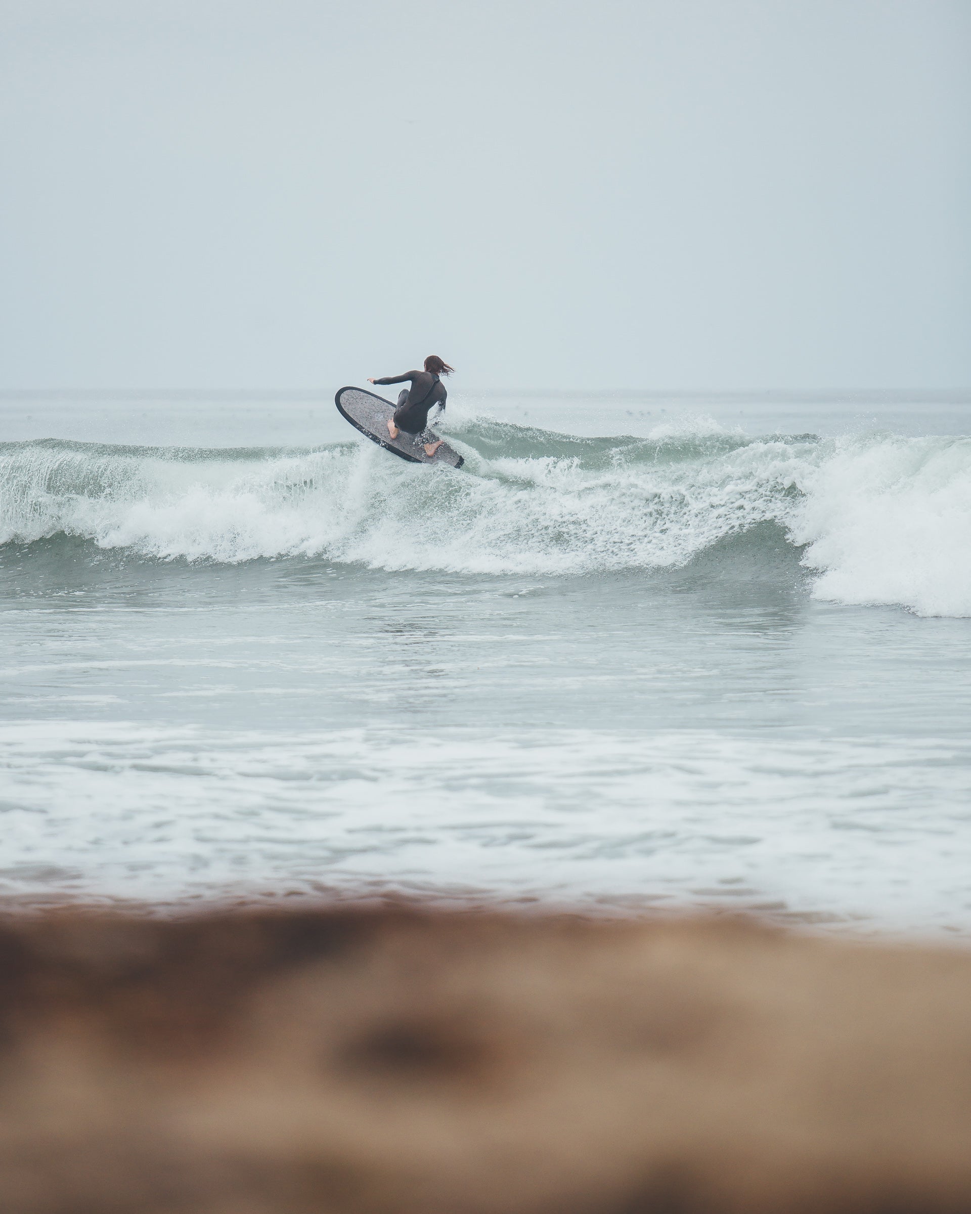 Man surfing on top of a wave with a 5 foot 4 inch Almond Secret Menu surfboard