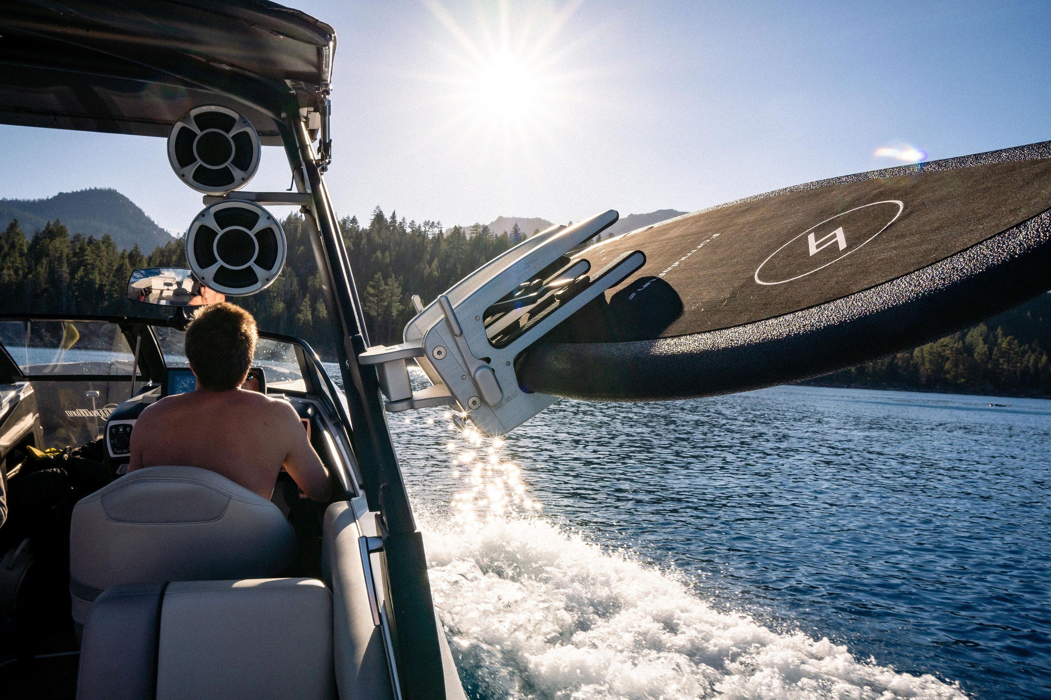 A black 4 foot 8 inch Formula Fun Rubicon Wake Surf Board in board holder on lake tahoe