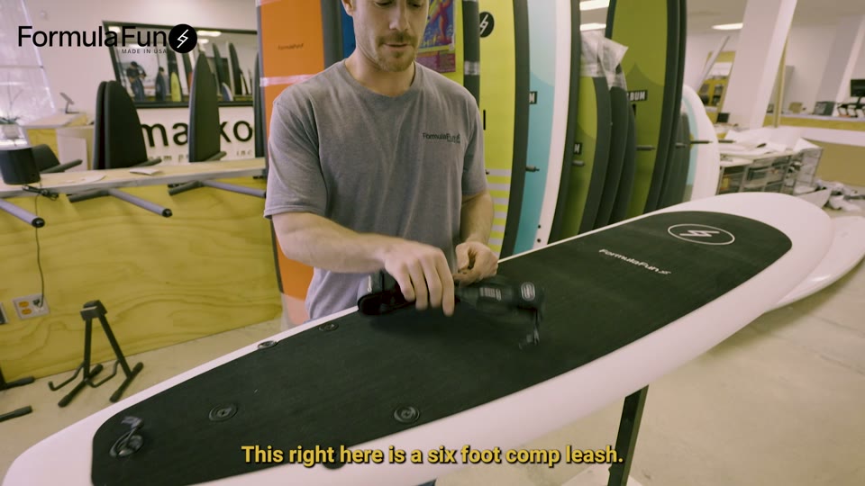 A surf leash being demonstrated on the deck of a Zippers board