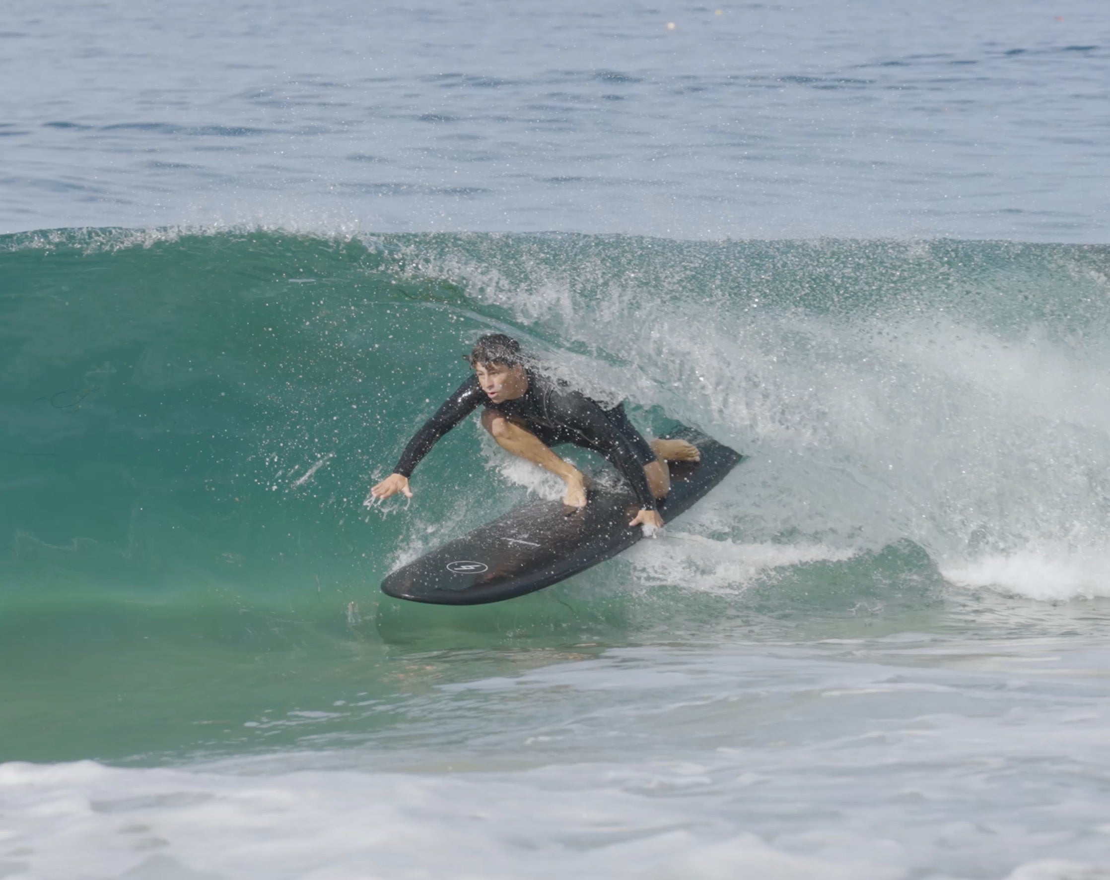 Man surfing a wave on a black Formula Fun Foamies surfboard 