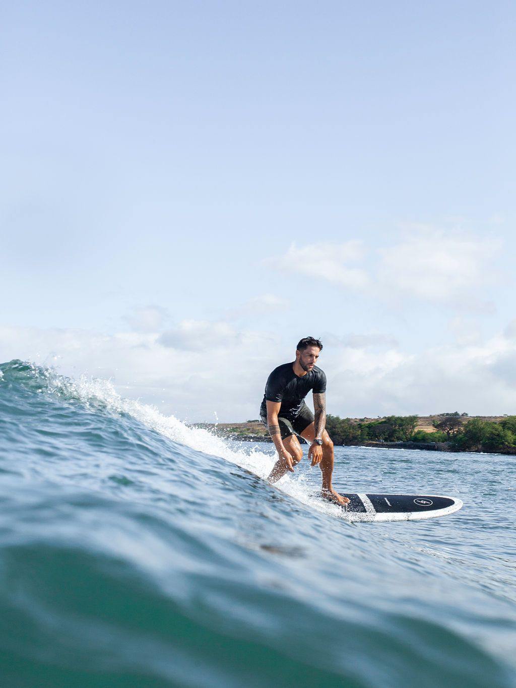 Man surfing a wave on a speckled 8 foot Formula Fun Foamies Rincon