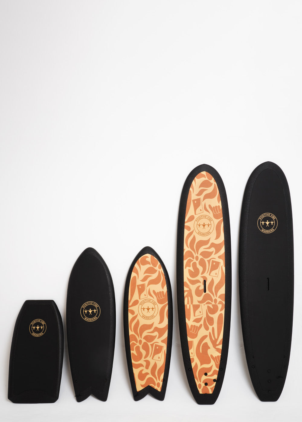 Positive Vibe Warriors surfboards of all shapes and sizes standing next to each other in a studio setting