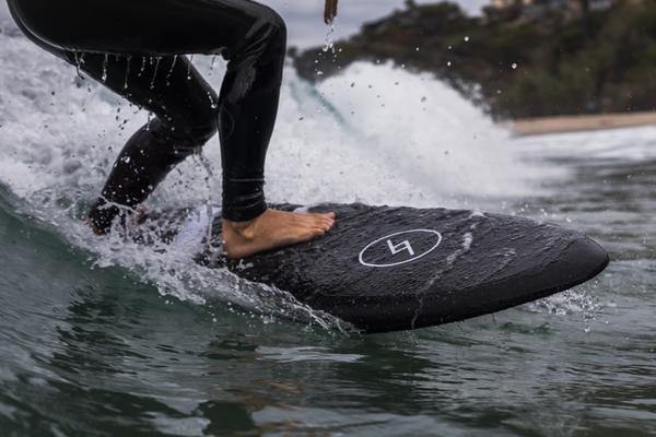 A man surfing on a black 5 foot 3 inch Formula Fun Foamies Twinnie surfboard