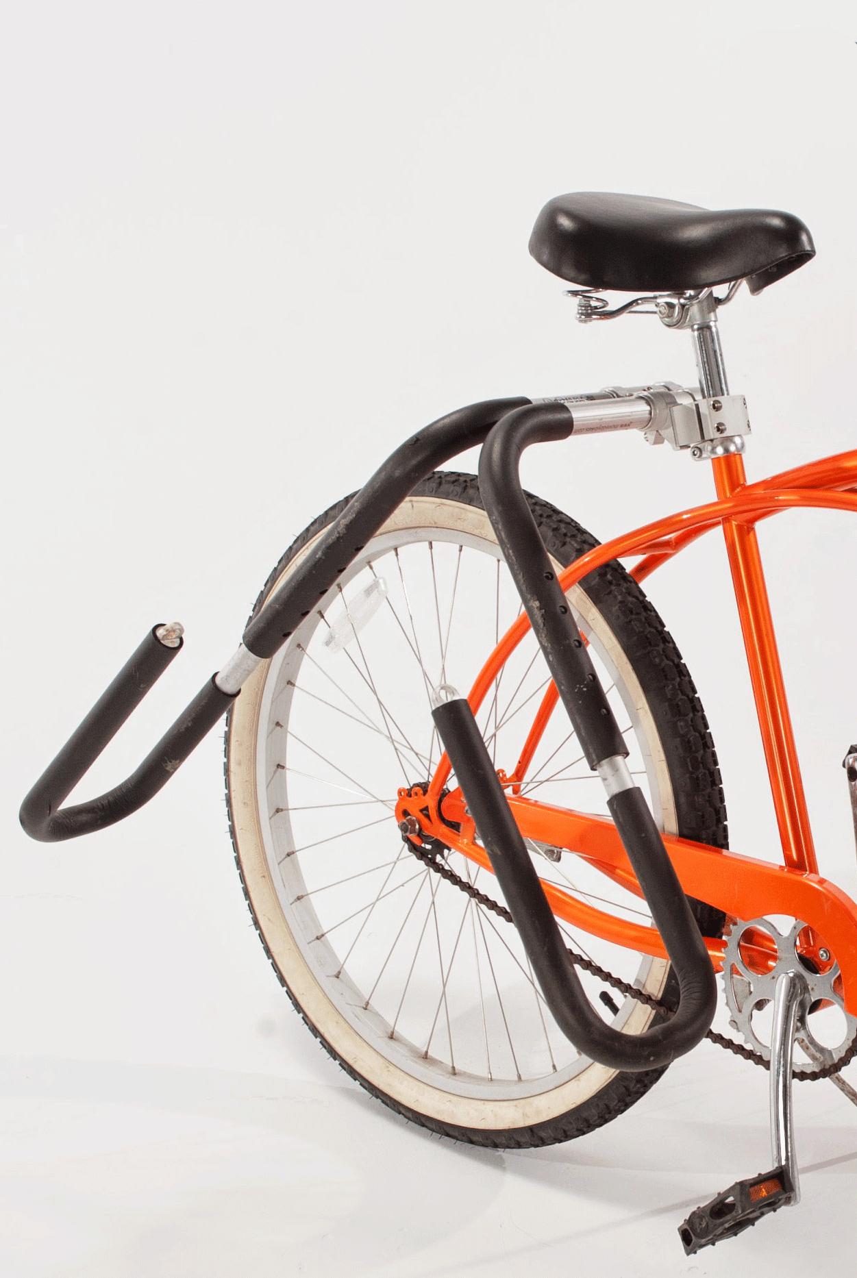The backside of an orange bike with an MBB surfboard rack